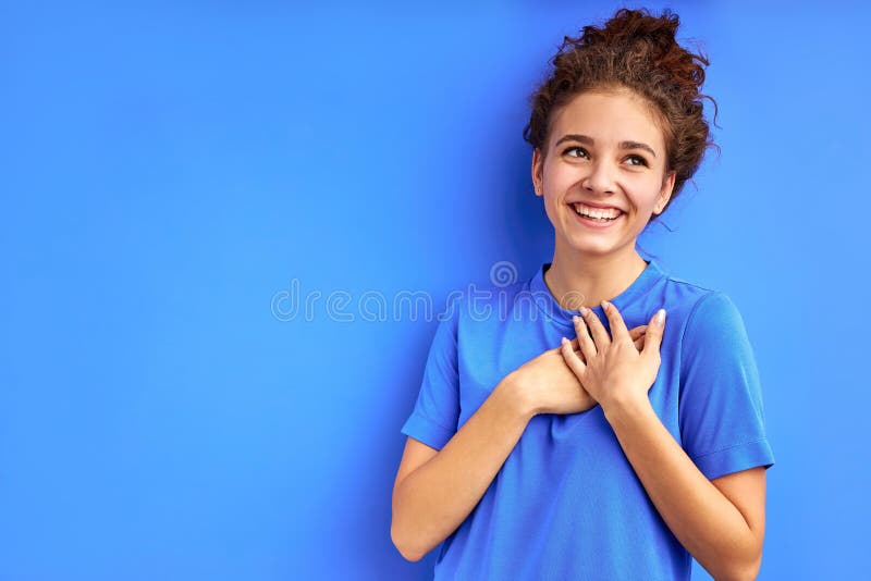 Portrait of nice pretty dreamy curly girl thinking fantasizing isolated on blue background