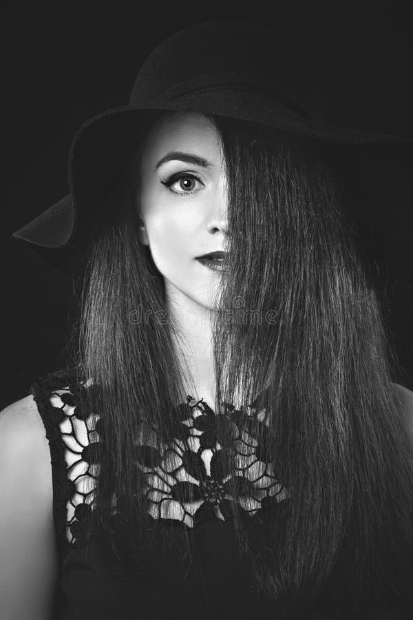 Portrait noir et blanc de femme dans le chapeau noir photographie stock