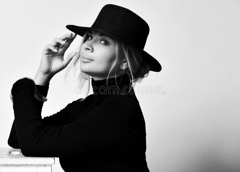 Portrait noir et blanc de la femme blonde fille romantique en chapeau noir avec brim et col de l'utérus nous regardant sur blanc photographie stock libre de droits Portrait noir et blanc de la femme blonde fille romantique en chapeau noir avec brim et col de l'utérus nous regardant sur blanc photographie stock libre de droits