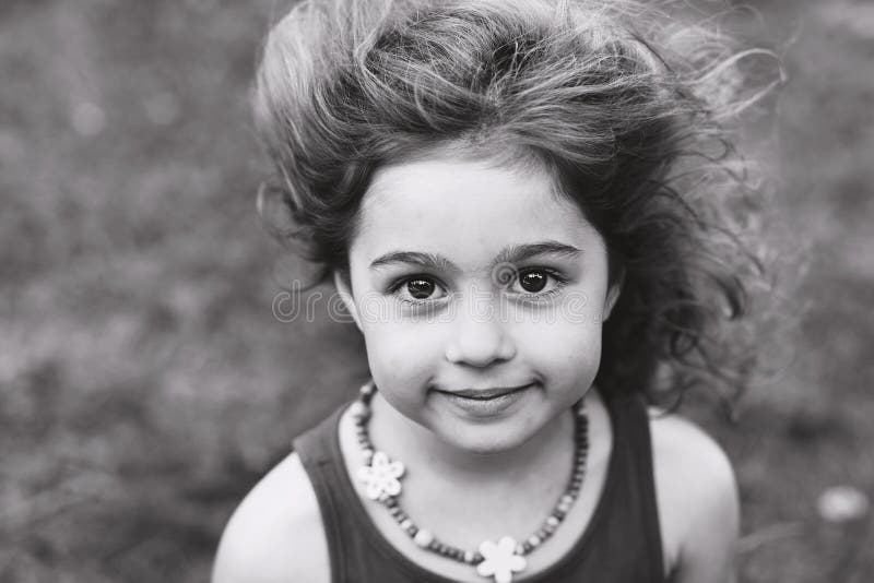 Portrait noir et blanc de la petite fille mignonne souriant dehors images libres de droits Portrait noir et blanc de la petite fille mignonne souriant dehors images libres de droits