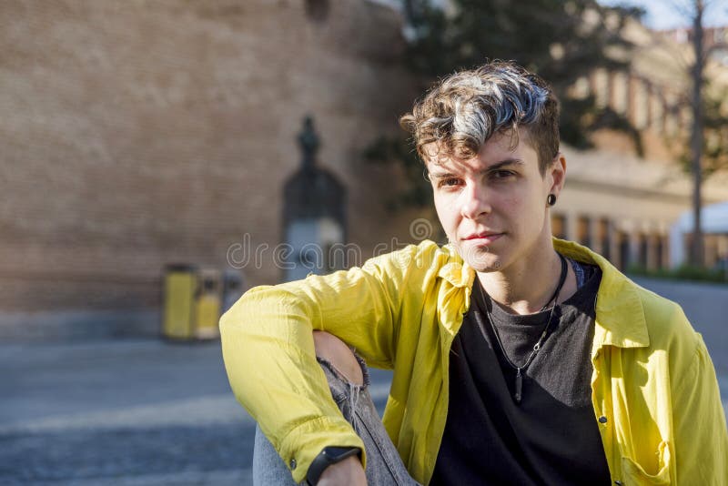 Portrait of a non binary person looking at camera while posing outdoors. royalty free stock photo