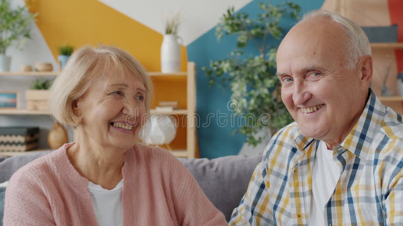 Portrait of old loving couple looking at each other and smiling then at camera