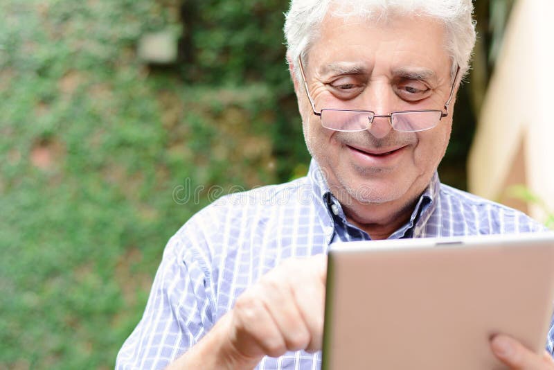 Old man using digital tablet. royalty free stock photography