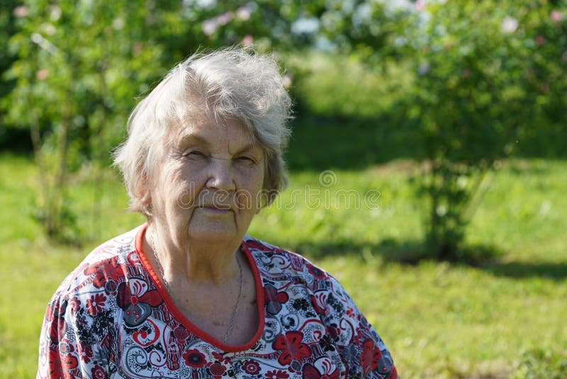 Portrait of old smiling woman in the gargen