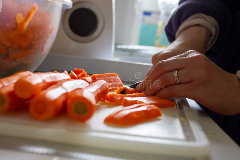 A Portrait of a Person Chopping Up Carrots into Small Pieces on a ...