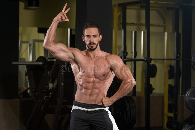 Portrait Of A Physically Fit Muscular Young Man. Bodybuilder, exercises.