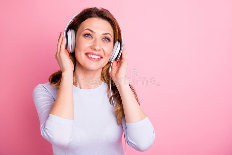 Portrait of positive cheerful woman have holidays sue headset listen music songs radio wear white jumper  over