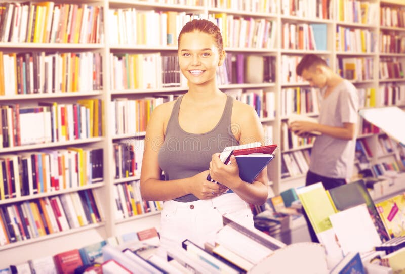 Portrait of positive girl teenager holding new books stock photo Portrait of positive girl teenager holding new books stock photo