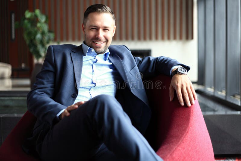 Portrait of positive young businessman sitting in a modern corporate environment, looking at the camera stock images Portrait of positive young businessman sitting in a modern corporate environment, looking at the camera stock images