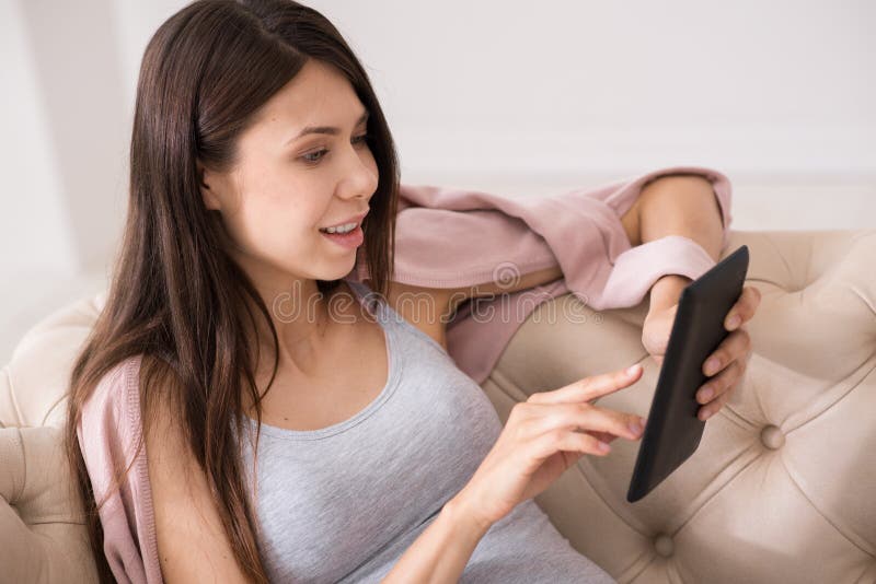 Portrait Of Pregnant Female That Pointing On Her Device Stock Image