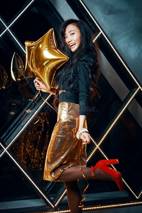 Portrait of pretty happy asian woman having fun and holding golden balloon stock photography Portrait of pretty happy asian woman having fun and holding golden balloon stock photography
