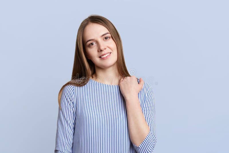 Portrait of pretty lovely young woman with dark ahir, pleasant charming smile and appearance, wears fashionable blouse, stands alo royalty free stock photos Portrait of pretty lovely young woman with dark ahir, pleasant charming smile and appearance, wears fashionable blouse, stands alo royalty free stock photos