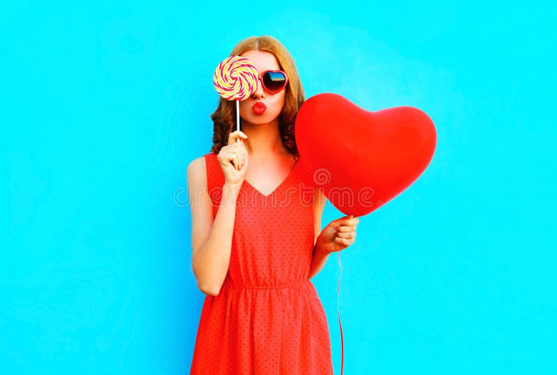 Portrait pretty woman with a lollipop candy, air balloon on blue