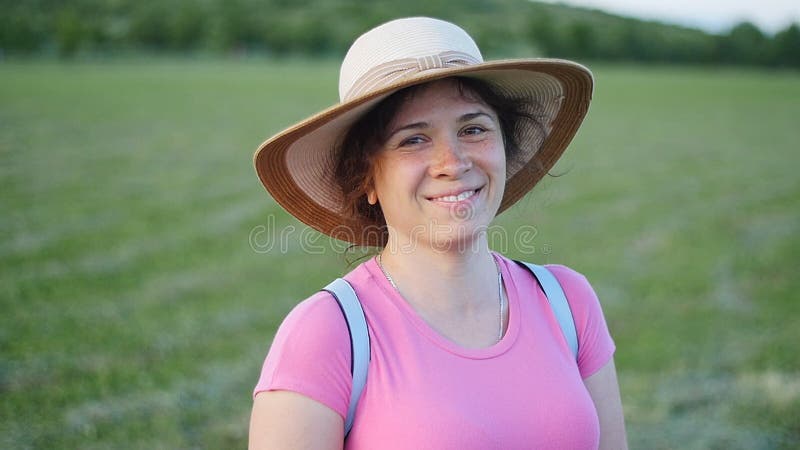 Portrait of pretty young lady in hat in a park