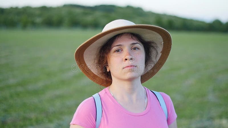 Portrait of pretty young lady in hat in a park