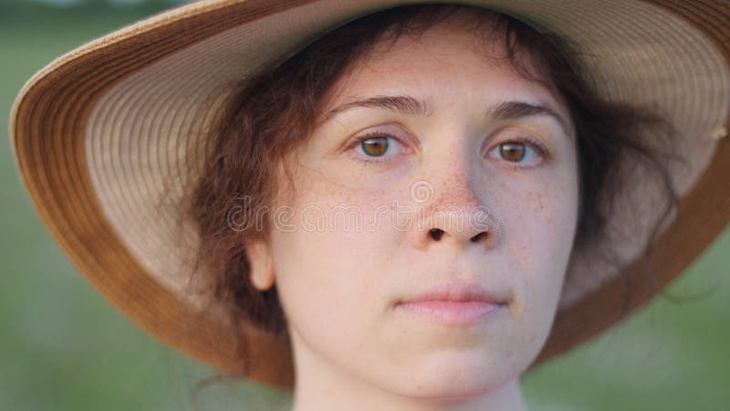 Portrait of pretty young lady in hat in a park