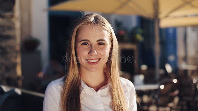 Portrait of pretty young woman looking at camera smiling face sunny day city street traveling sightseeing enjoying