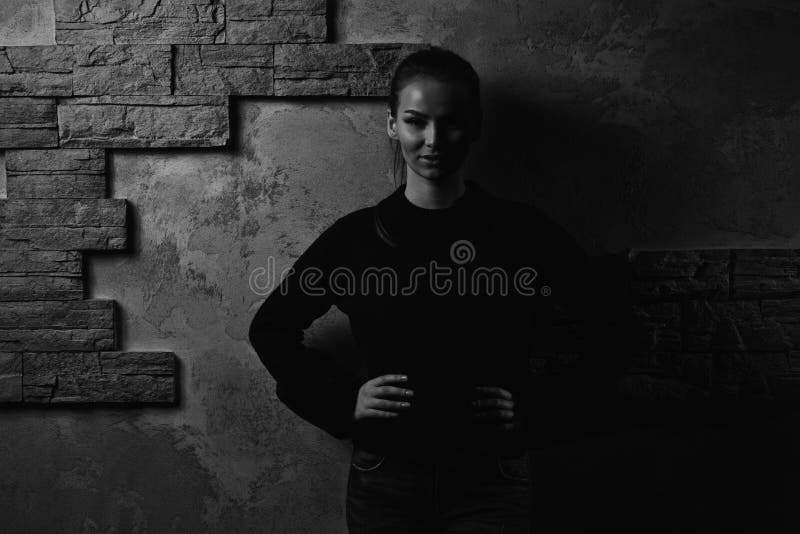 Portrait Of Pretty Young Woman Standing Against Brick Wall Stock Photo