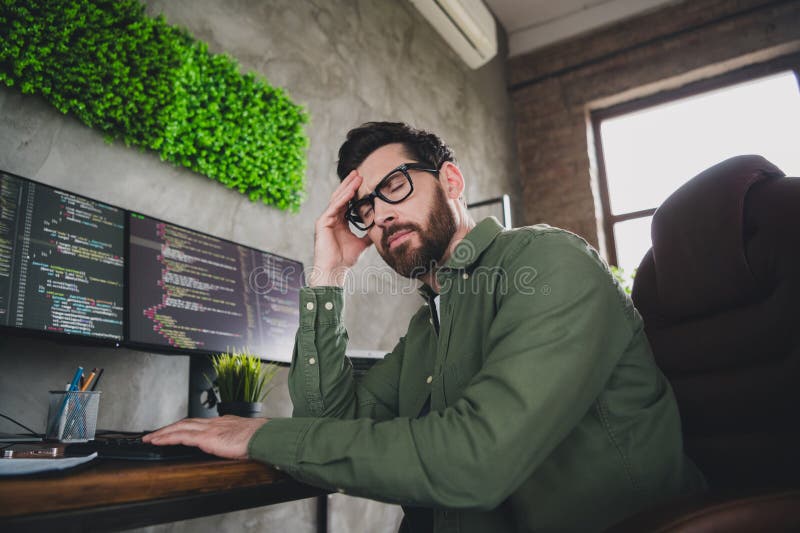 Portrait of professional hacker young man headache computer desk loft interior office indoors stock image