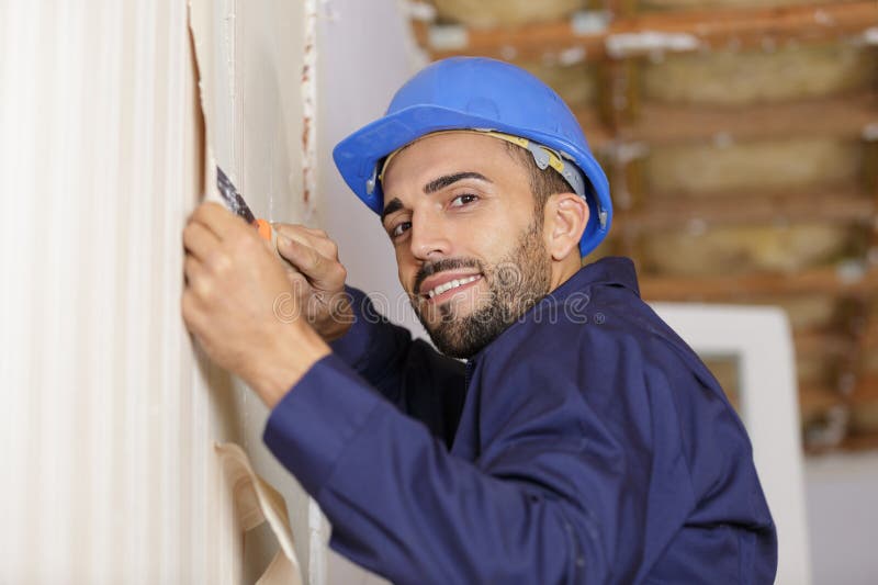 Portrait Professional Man Stripping Wallpaper with Scraper Stock Photo