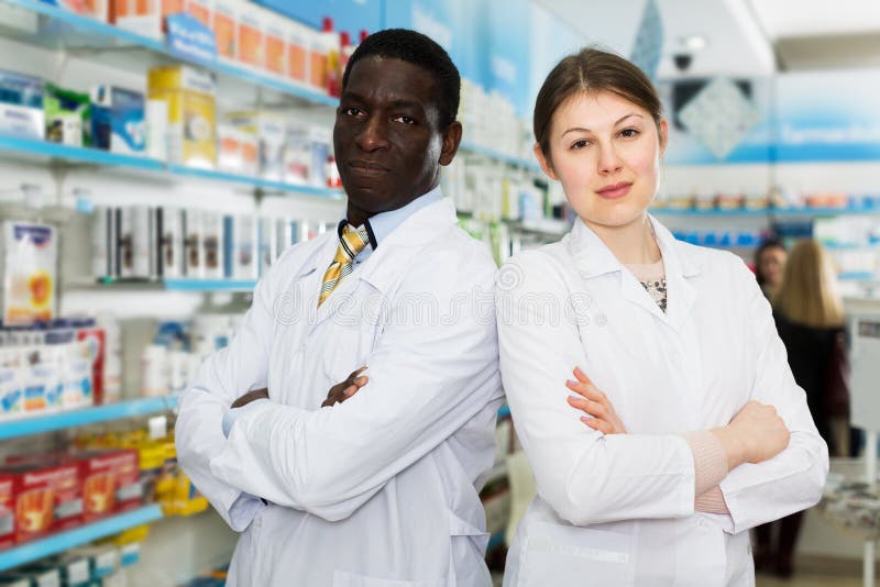 Portrait of professional multinational team of pharmacists posing in modern drugstore. Portrait of professional multinational team of pharmacists posing in modern drugstore