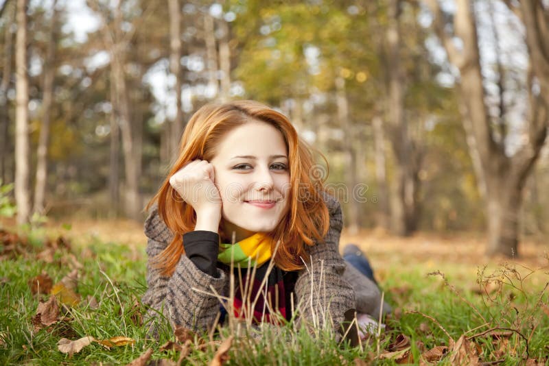 Portrait of red-haired girl in the autumn park.