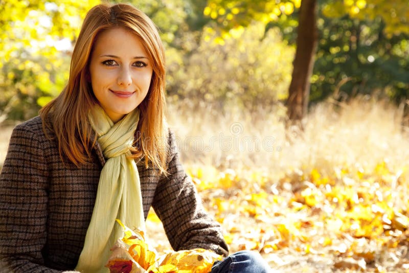 Portrait of red-haired girl in the autumn park