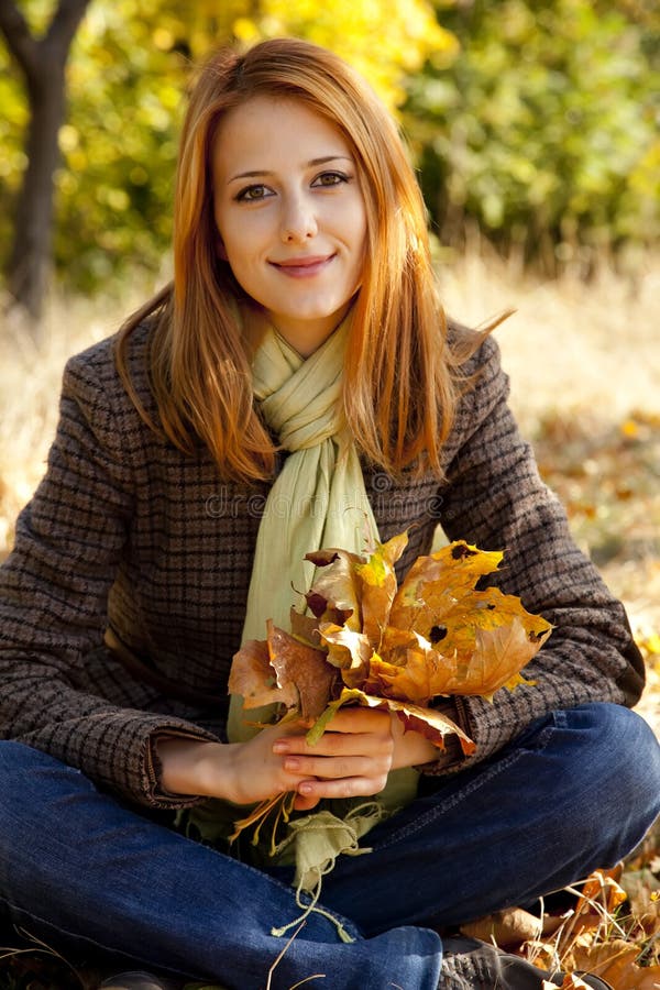 Portrait of red-haired girl in the autumn park