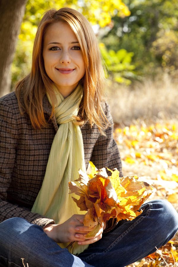 Portrait of red-haired girl in the autumn park