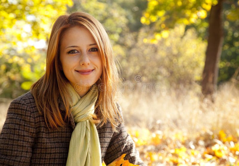 Portrait of red-haired girl in the autumn park