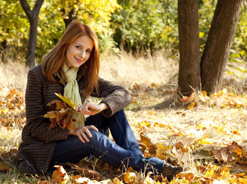 Portrait of red-haired girl in the autumn park