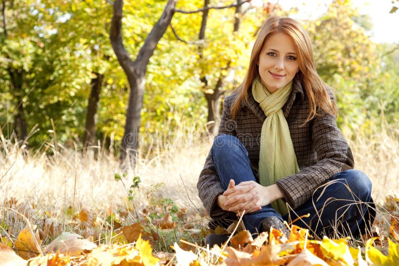 Portrait of red-haired girl in the autumn park