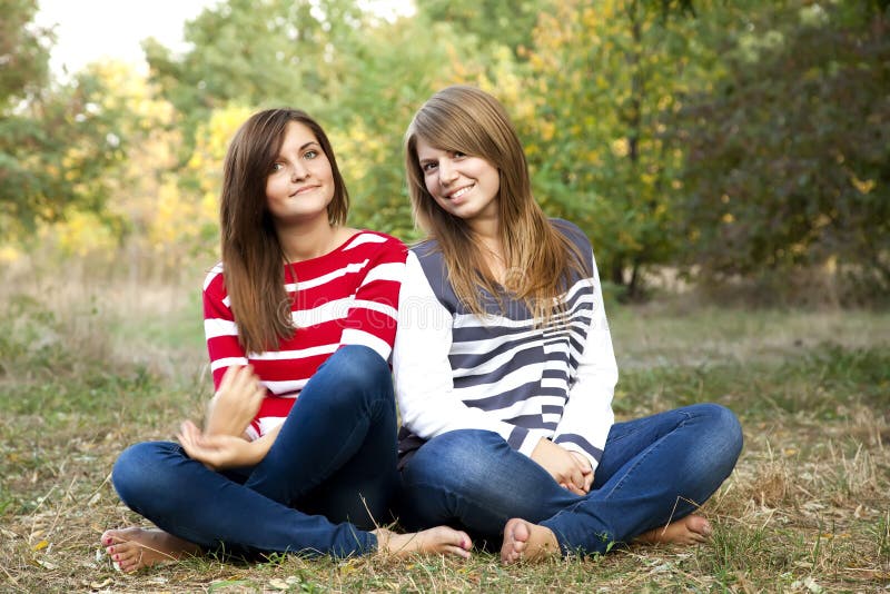 Portrait of redhead and brunette girls at outdoor.