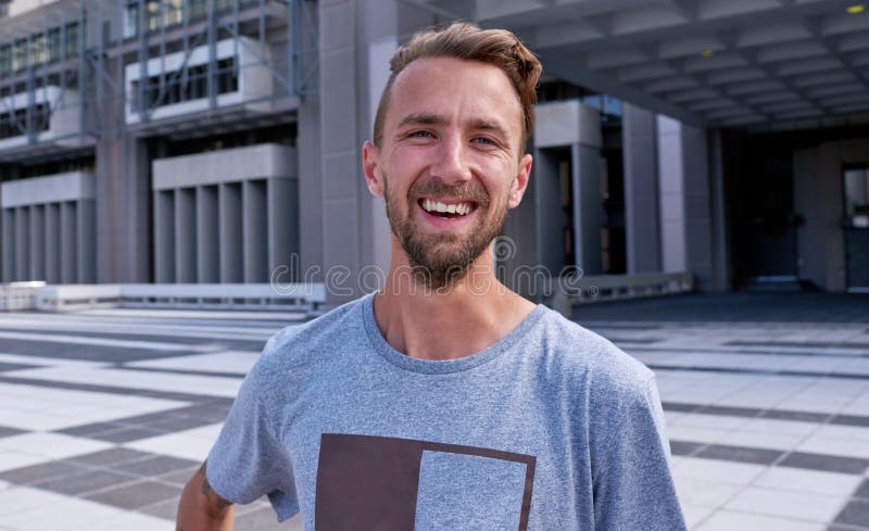 Portrait riant et homme en ville confiant et de la banlieue sur la rue et drôle de plaisanterie en voyage. Voyage extérieur photos libres de droits