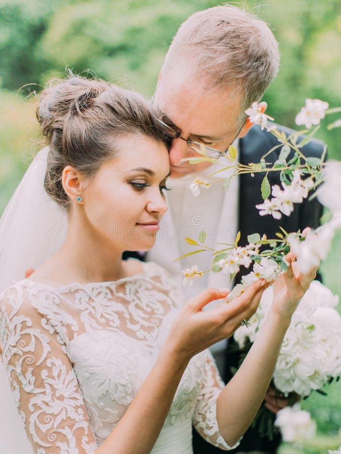 Portrait romantique extérieur des nouveaux mariés étreignants appréciant le temps dans le jardin photo stock