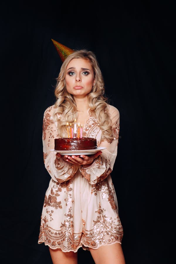 Portrait of a sad young beautiful blond woman holding birthday cake with candles stock image Portrait of a sad young beautiful blond woman holding birthday cake with candles stock image
