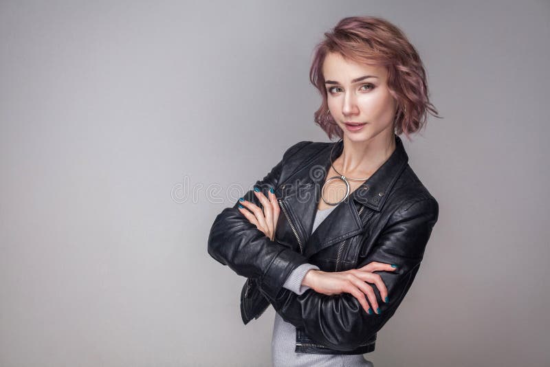 Portrait of satisfied beautiful happy girl with short hair and makeup in casual style black leather jacket standing crosed hands stock photo Portrait of satisfied beautiful happy girl with short hair and makeup in casual style black leather jacket standing crosed hands stock photo
