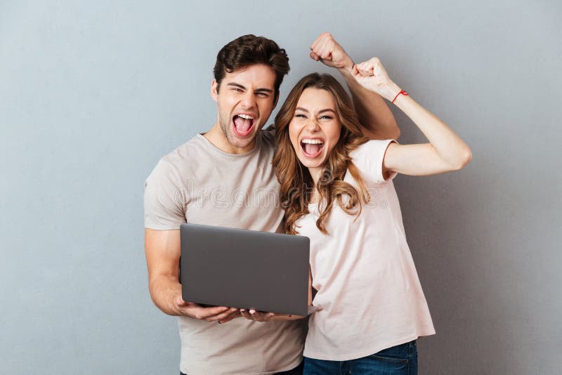 Portrait of a satisfied happy couple holding laptop computer stock photo Portrait of a satisfied happy couple holding laptop computer stock photo