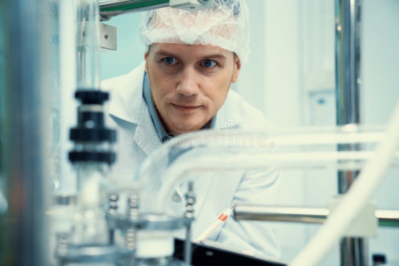 Portrait of a scientist, apothecary extracting cannabis oil in laboratory.