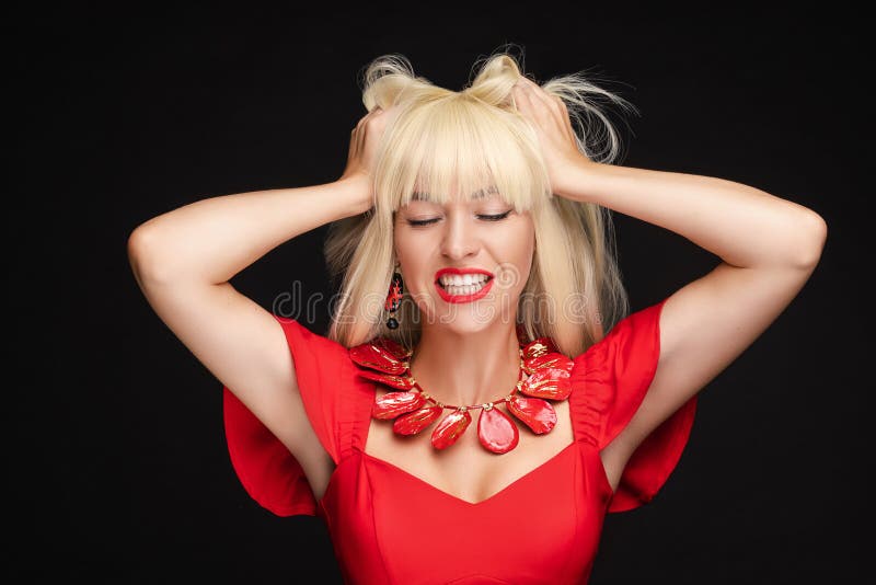 Portrait of screaming fashion blonde woman in red dress holding head having negative emotion