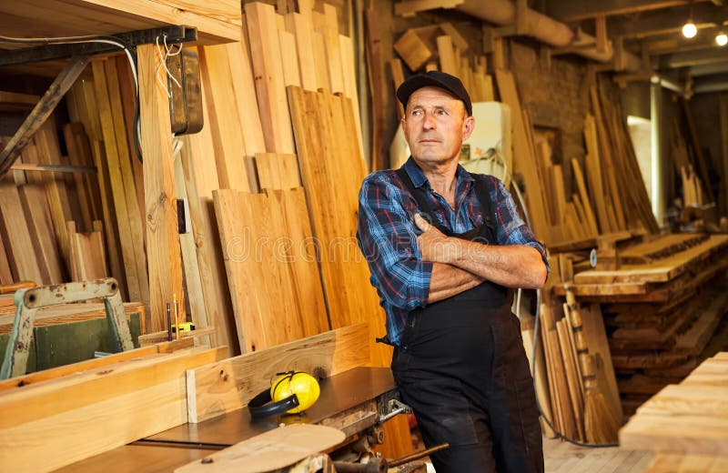 Portrait of Senior Carpenter in Uniform Works on a Woodworking Machine