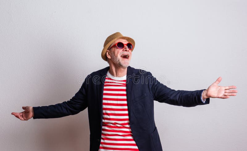 Portrait of a senior man with red sunglasses in a studio, arms stretched. stock image Portrait of a senior man with red sunglasses in a studio, arms stretched. stock image