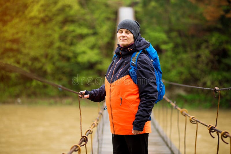 Portrait Of Senior Woman with backpack On Hike cross river royalty free stock photo Portrait Of Senior Woman with backpack On Hike cross river royalty free stock photo