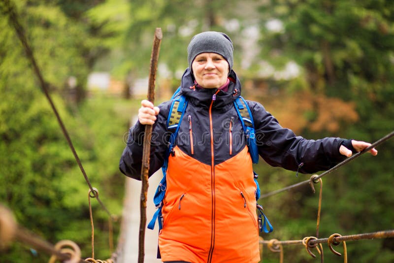 Portrait Of Senior Woman with backpack On Hike cross river royalty free stock photography Portrait Of Senior Woman with backpack On Hike cross river royalty free stock photography