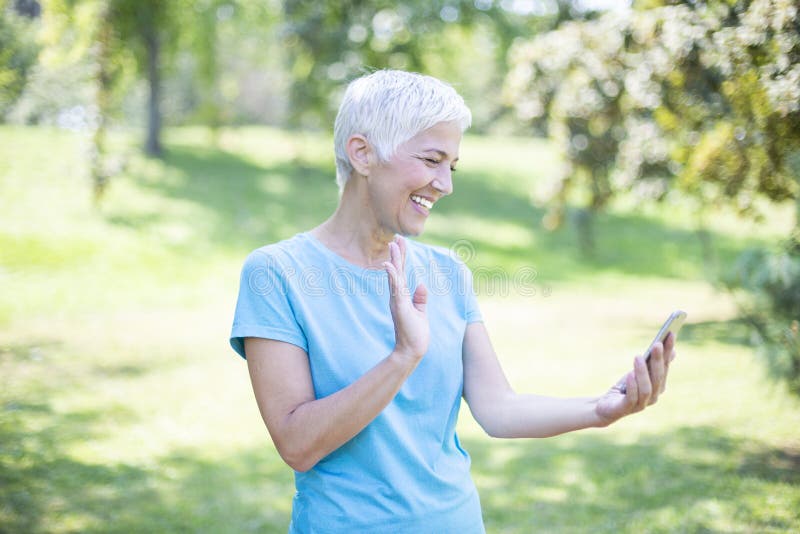 Portrait of senior woman in sports clothing using smart phone outdoor royalty free stock photography Portrait of senior woman in sports clothing using smart phone outdoor royalty free stock photography