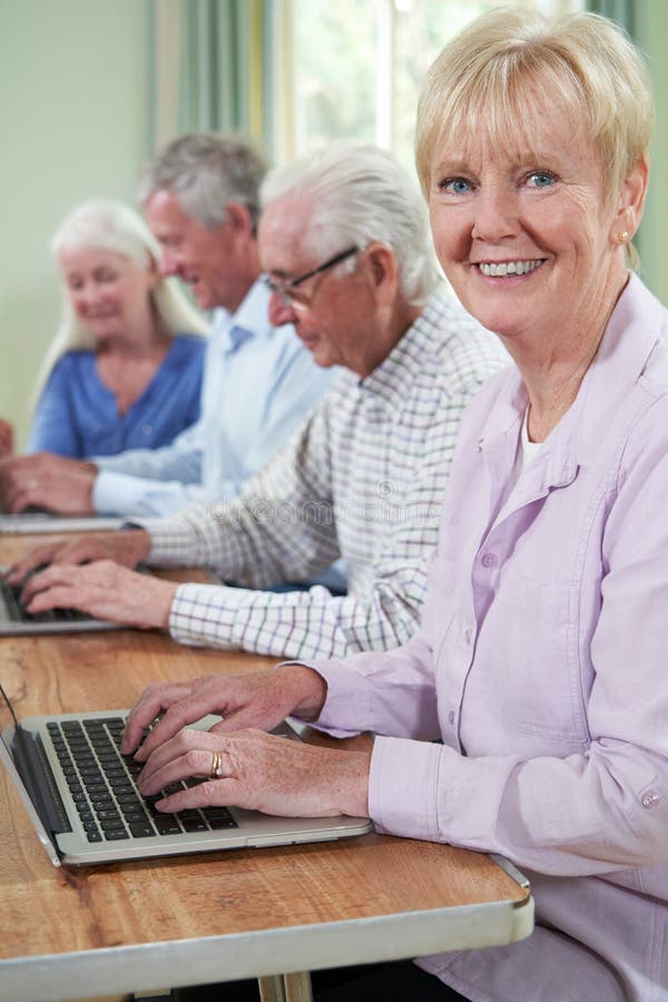 Portrait of Senior Woman with Tutor in Computer Class Stock Photo
