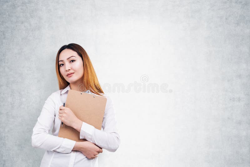 Serious Asian woman with clipboard and pen, mock up royalty free stock photo Serious Asian woman with clipboard and pen, mock up royalty free stock photo