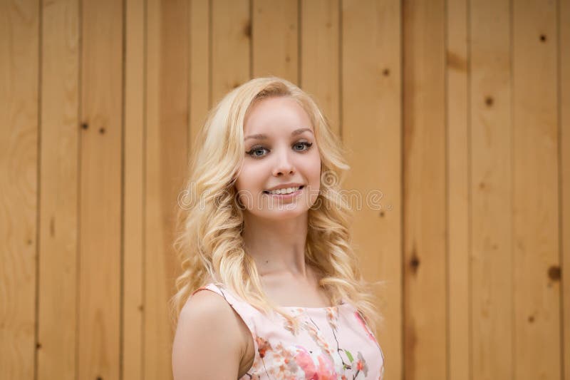 Portrait of a sexy young female blonde on a background of wooden boards.