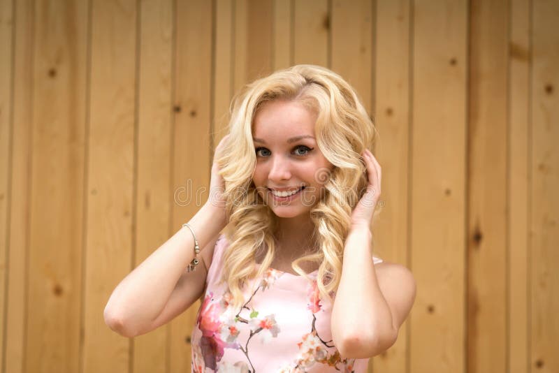 Portrait of a sexy young female blonde on a background of wooden boards.