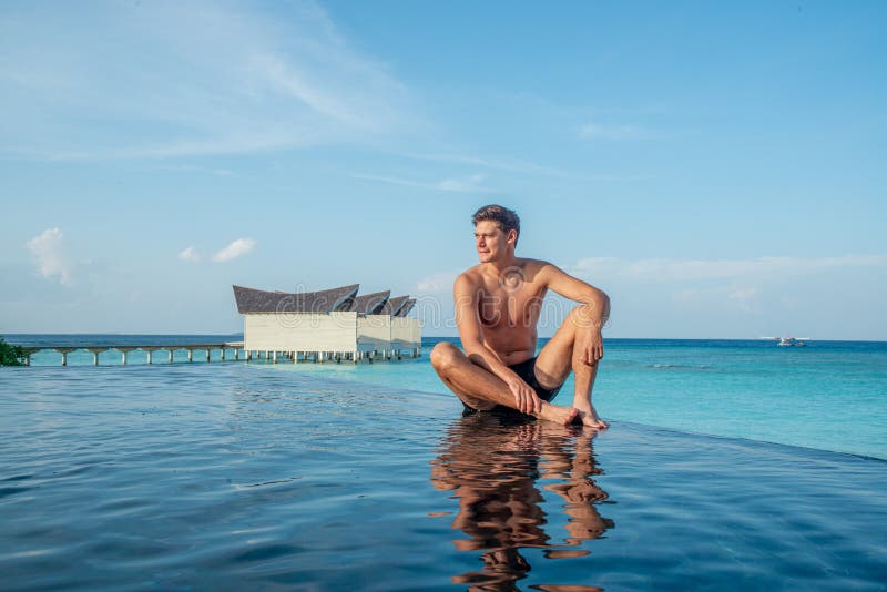 Portrait of sexy young handsome man in infinity swimming pool at the tropical island luxury resort royalty free stock photos Portrait of sexy young handsome man in infinity swimming pool at the tropical island luxury resort royalty free stock photos